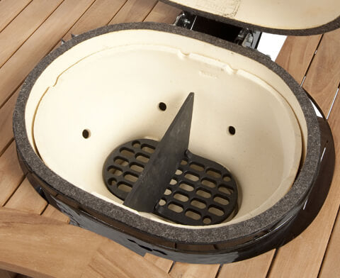 Primo cast-iron firebox divider installed in an oval grill; grill sold separately